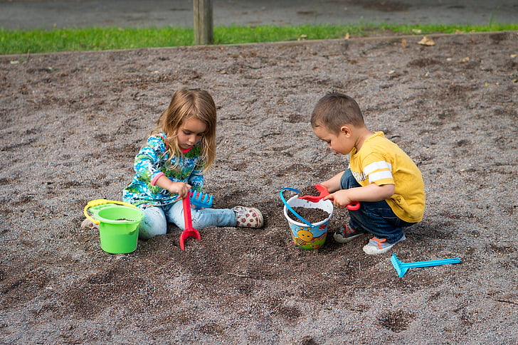 two child playing on sand