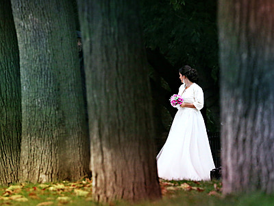 woman in white wedding dress holding pink boquet