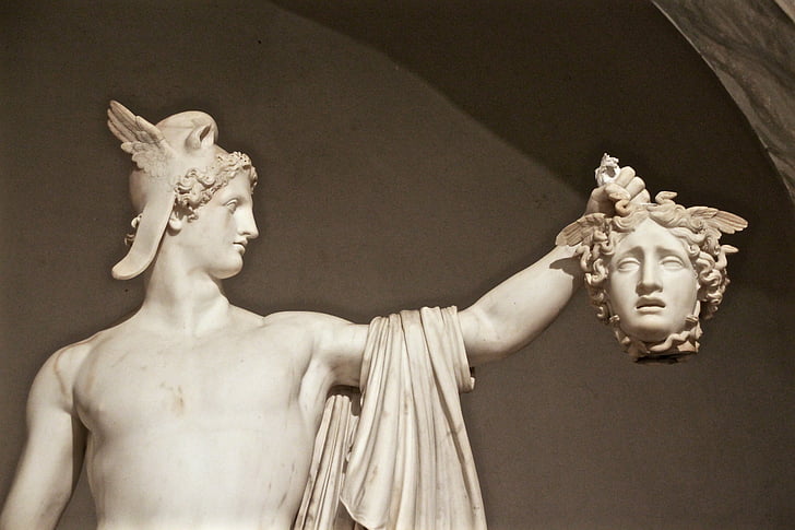 white concrete man holding head of woman statue