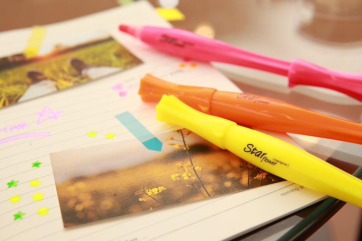 three yellow, pink, and orange pens