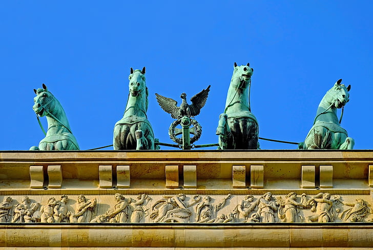 four gray concrete horse statues on roof