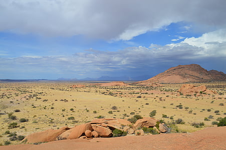 landscape photography of brown hill under cloudy sky