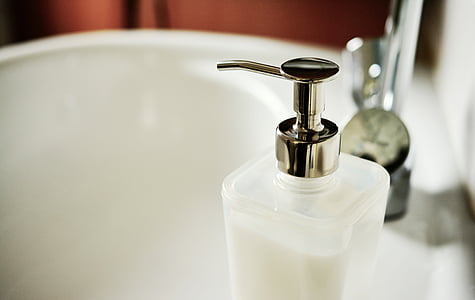 clear glass pump bottle on ceramic sink