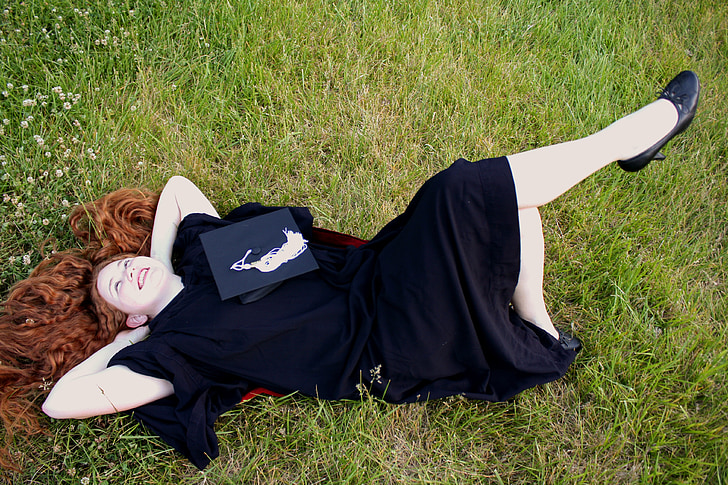 woman lying on green grass field