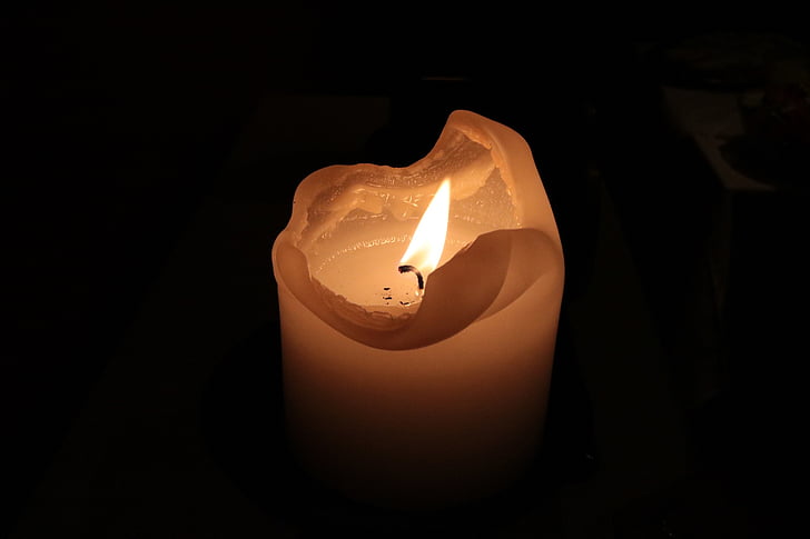 ignited white pillar candle