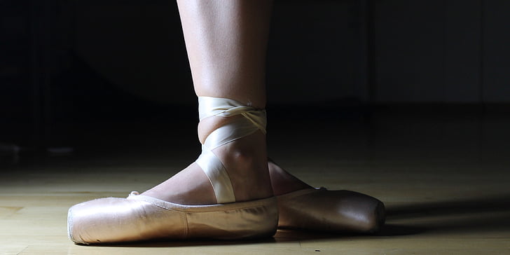 photo of ballerina on beige parquet floor