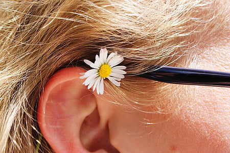 close up photography of white petaled flower placed on human ear