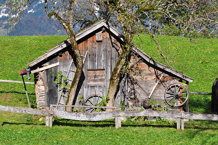 brown wooden barn around green grass field