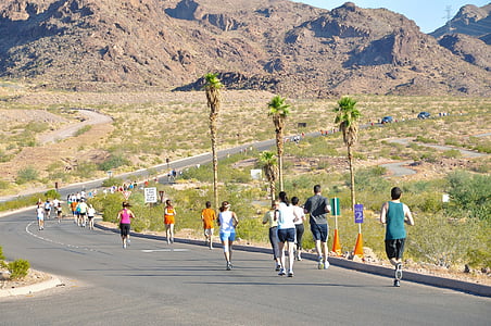 group of people running on road near mountain