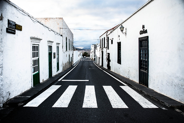 black asphalt road between white painted buildings