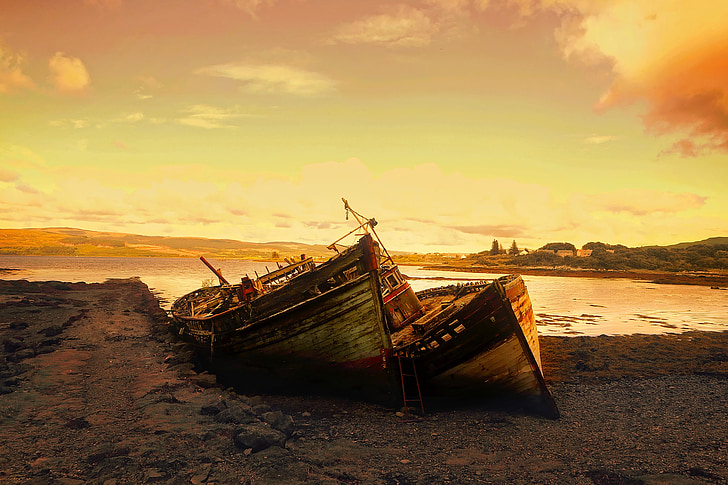 two brown boats dock on beach sand during golden hour