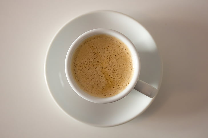 white ceramic coffee mug filled with brown liquid on round white ceramic saucer