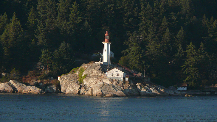 white and orange lighthouse near body of water