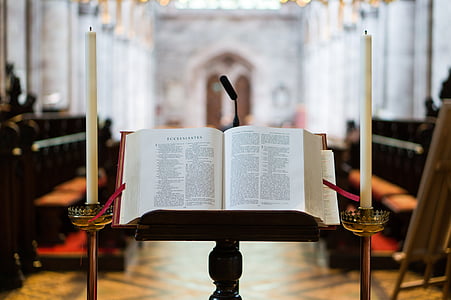 bible on stand near candlesticks