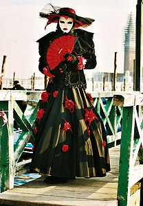 woman in black and red floral maxi dress on wooden bridge