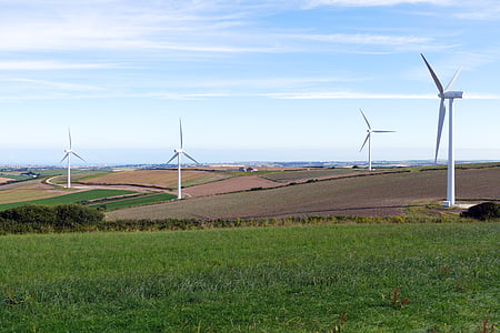 four white windmills in middle of field