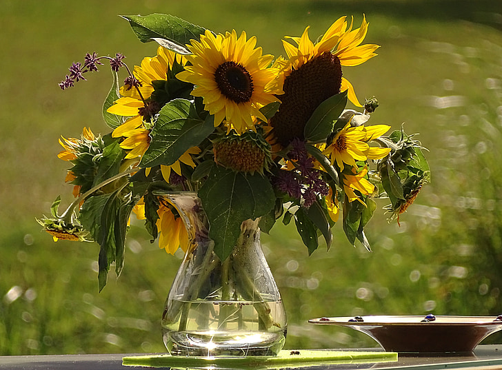sunflowers in glass vase on glass table