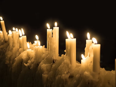 closeup photo of stick candles burning on black background