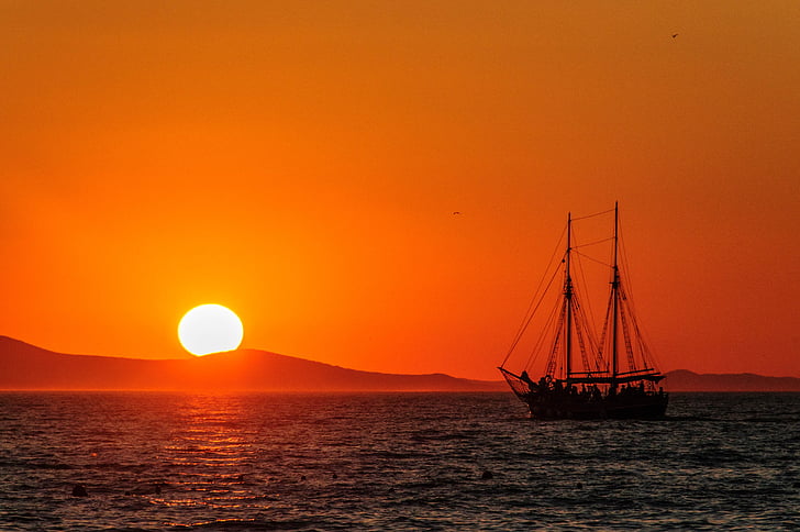 silhouette of boat during sunset