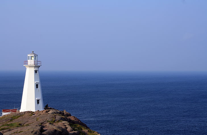 white painted lighthouse near body of water