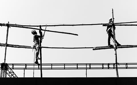 two men on scaffolding under sunny sky