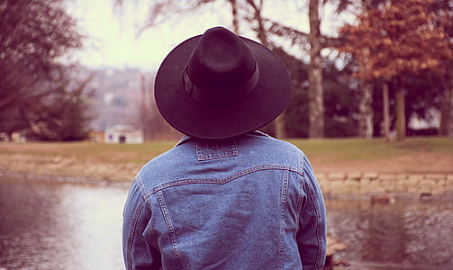 person wearing blue denim jacket and black hat