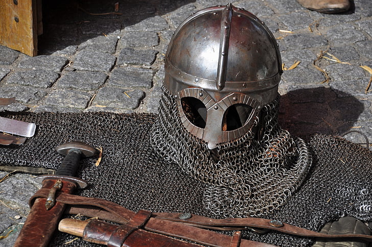 gray chain mail helmet and armor on gray brick floor