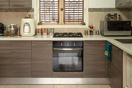 brown wooden kitchen cabinet with built in gas range oven