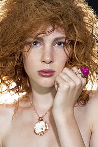 woman's wearing flower necklace and ring