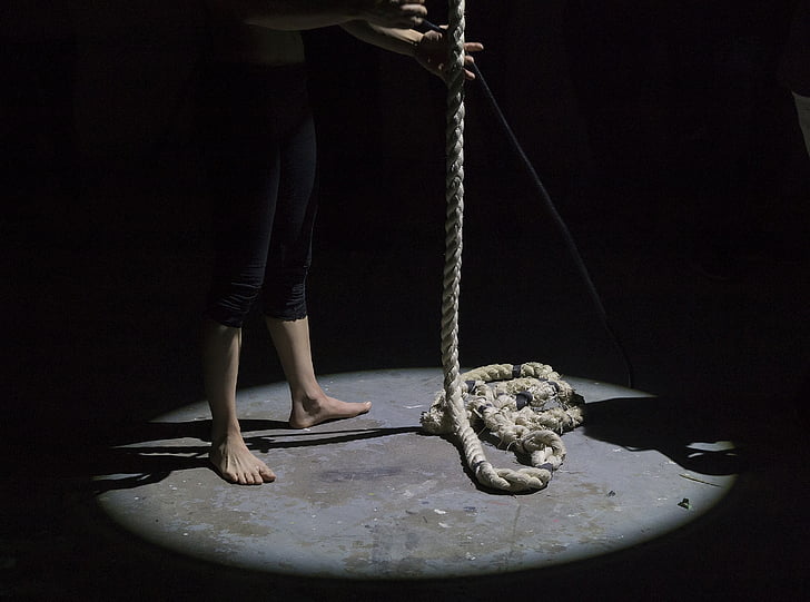person standing on floor holding brown rope