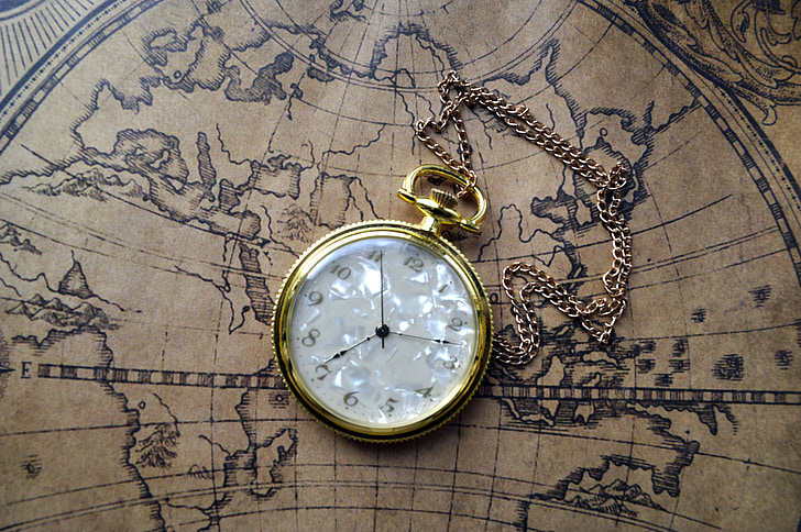 round gold-colored framed analog pocket watch on brown map