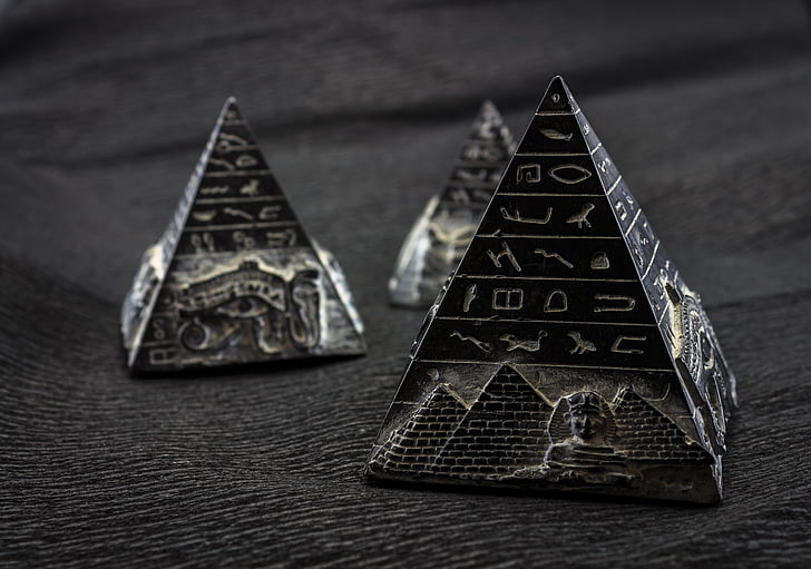 three black pyramid miniatures on black textile