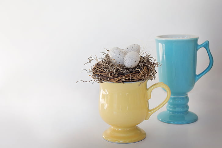 yellow and teal ceramic footed mugs with three eggs