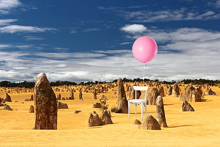 white chair with balloon on brown soil ground