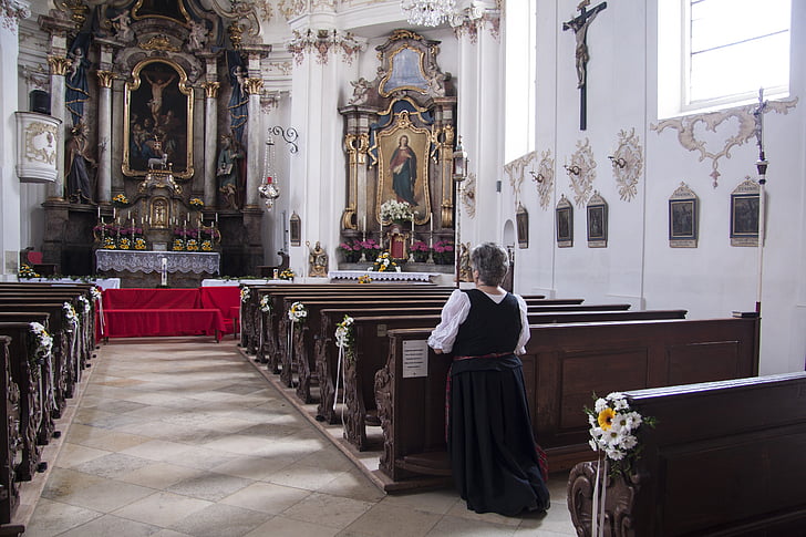 woman kneeling her nee on church while prayingh