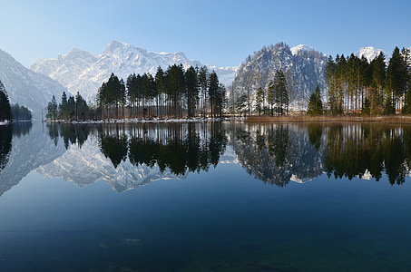 body of water near trees and mountains