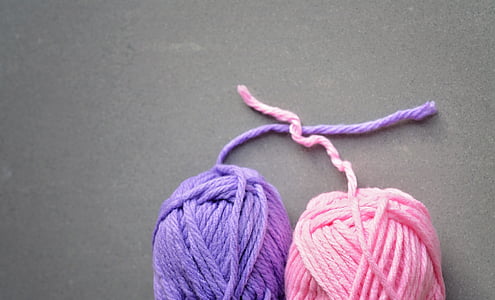 two purple and pink yarns on gray surface