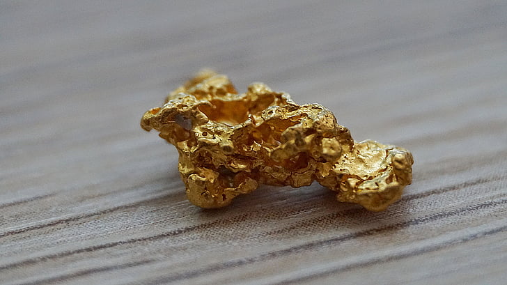 selective focus photography of gold-colored stone