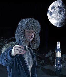 man holding gray shot glass during full moon