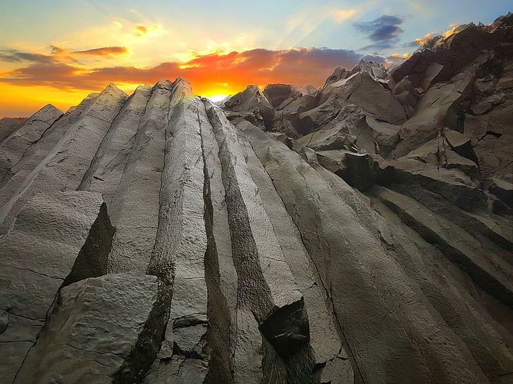 low angle photography of mountain against sunset