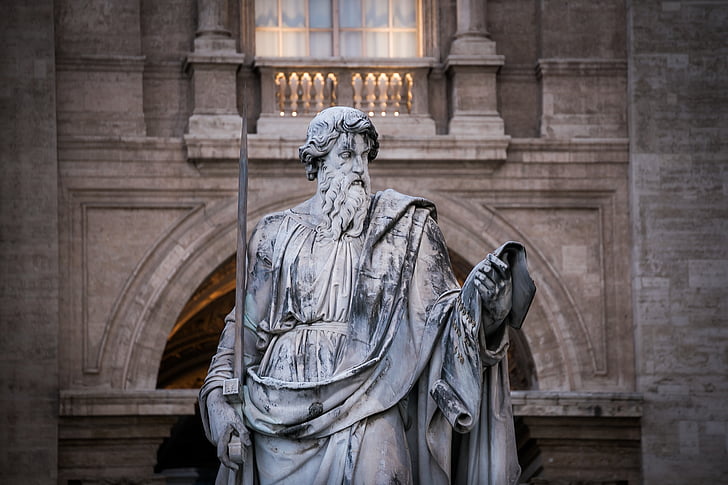 closeup photo of man holding bar statue