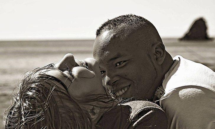 smiling man looking on woman in grayscale photography