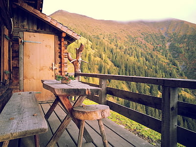 rectangular brown wooden table with chairs near mountain at daytime