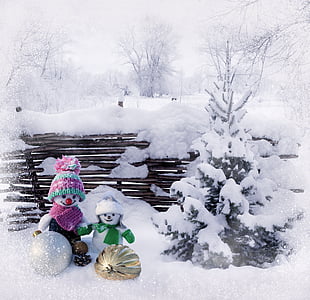 two snowmen beside snowy tree