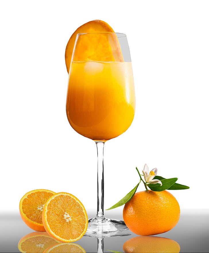 orange fruit beside clear long-stemmed wine glass