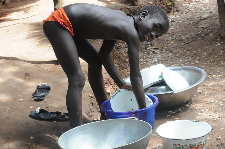 boy wearing brief washing dish during daytime
