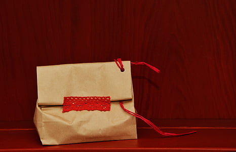 beige paper bag on red surface