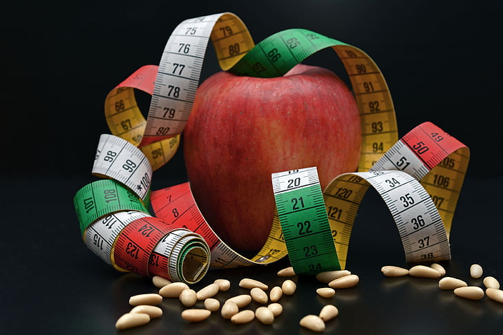 red apple fruit with measuring tape