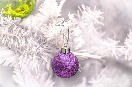 glitter purple bauble hanging on white Christmas tree
