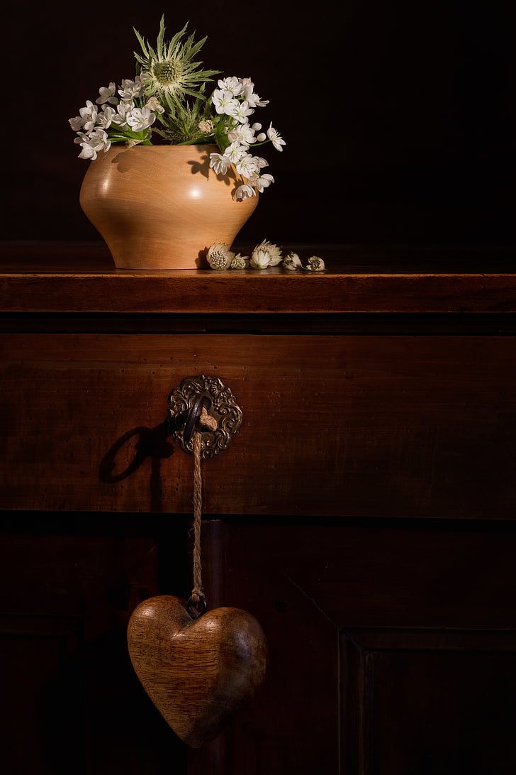 green leafed plant on brown vase on top brown wooden table